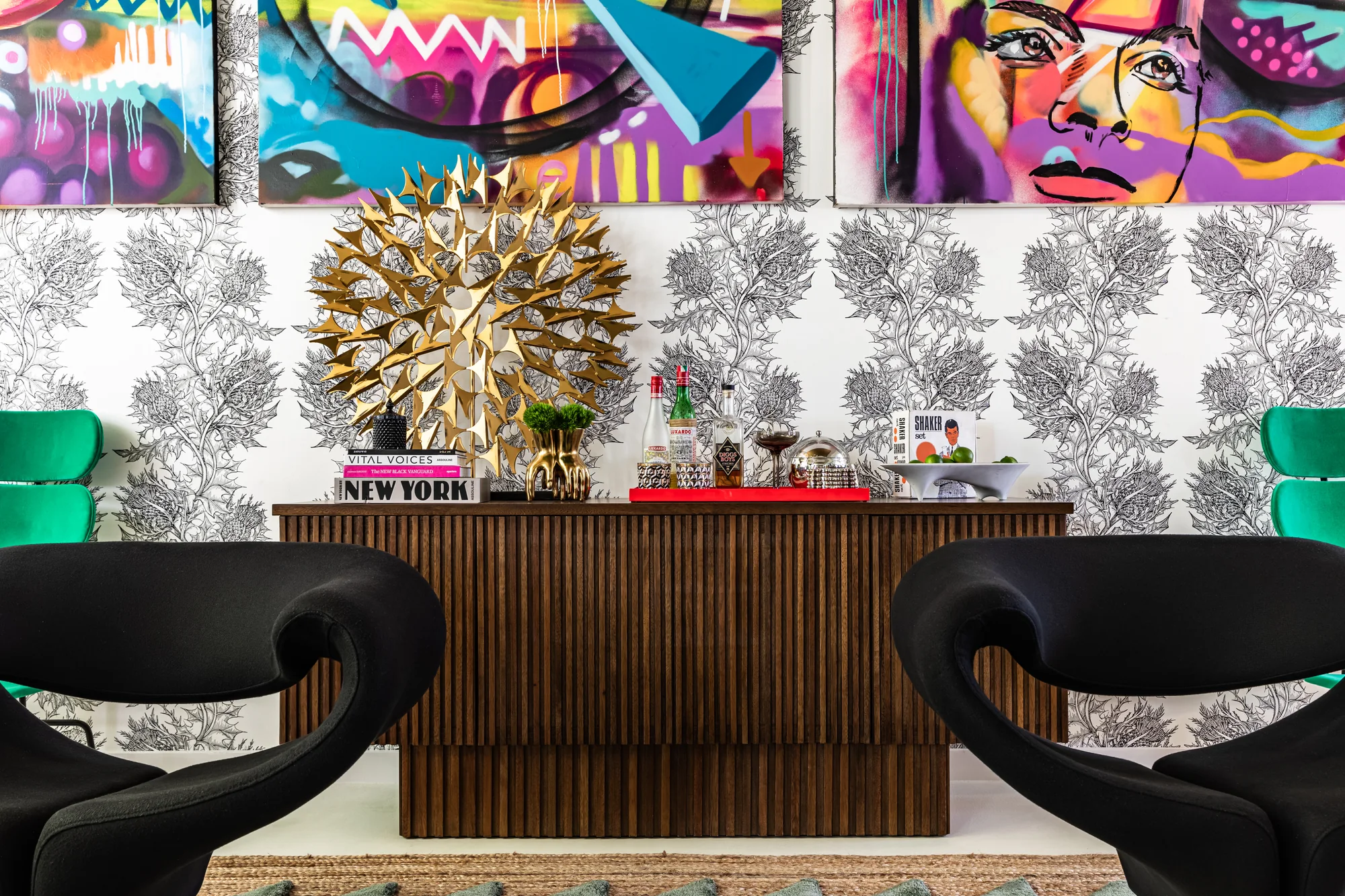 Office wall of street-art canvases above a walnut credenza