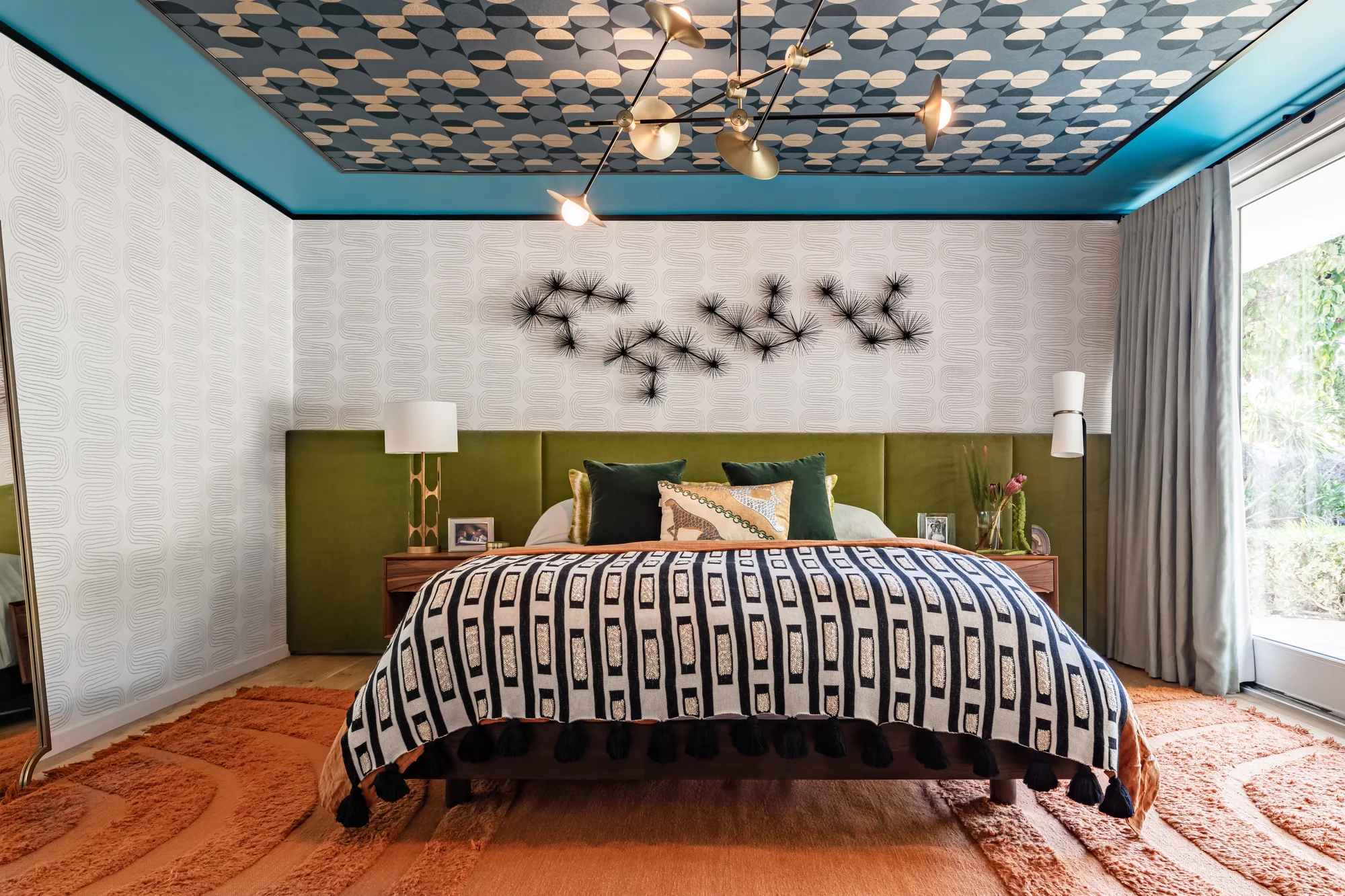 Primary bedroom with a patterned teal ceiling and olive headboard