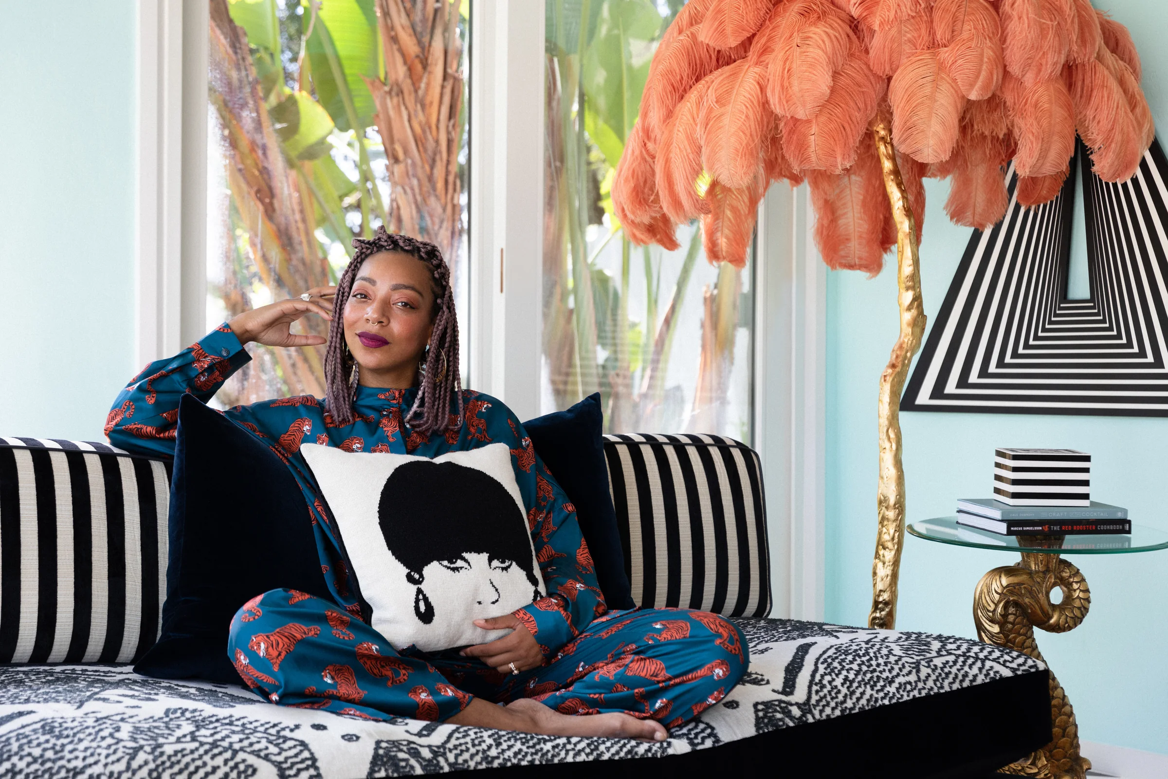 Carmen reclining on the black-and-white patterned daybed