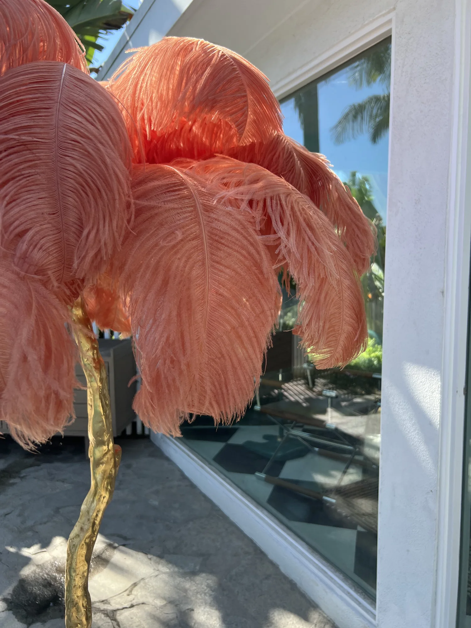 The feather lamp reflected in a mirror, framing the pool beyond