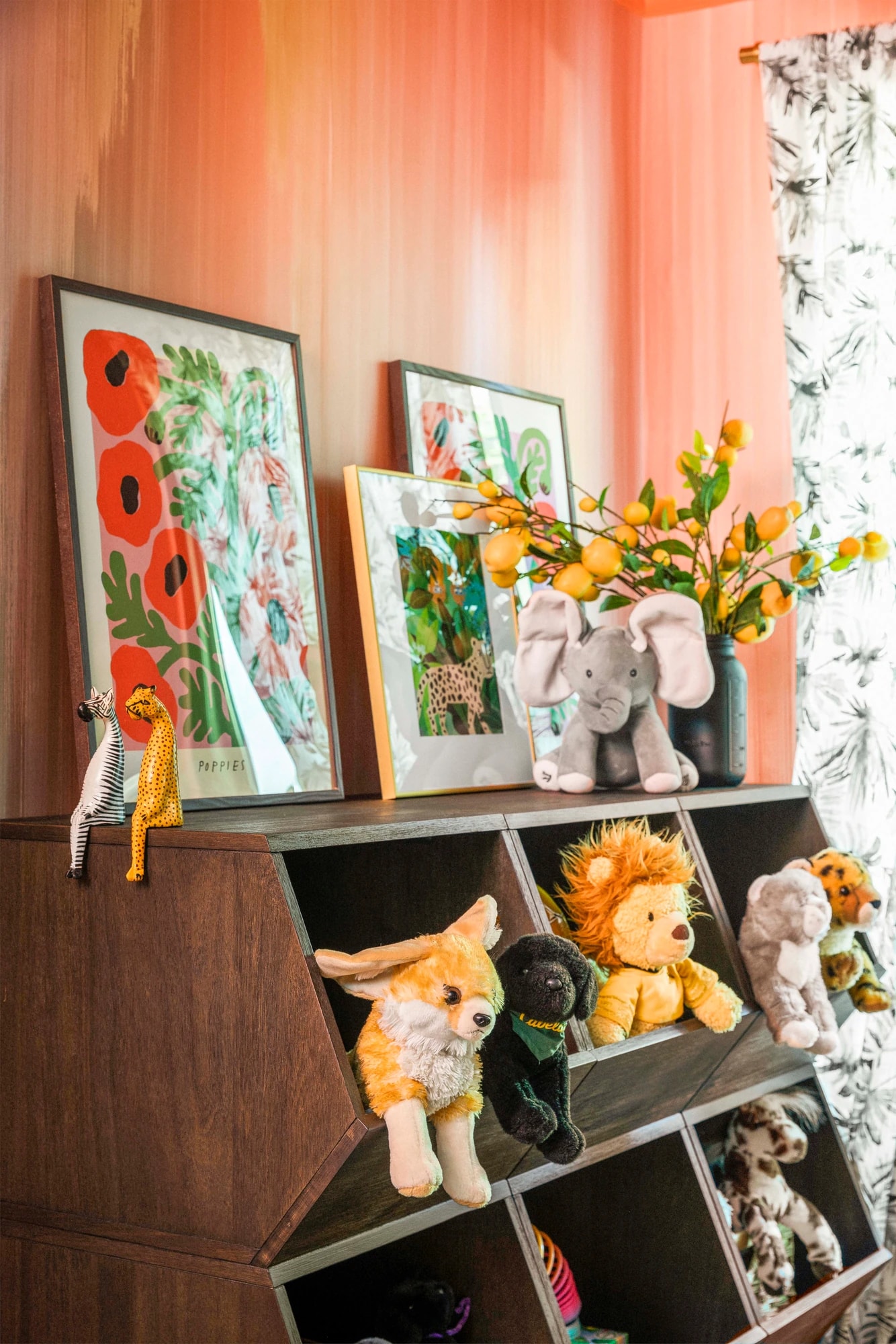 Stuffed animals tucked into the cubbies beneath framed children’s artwork