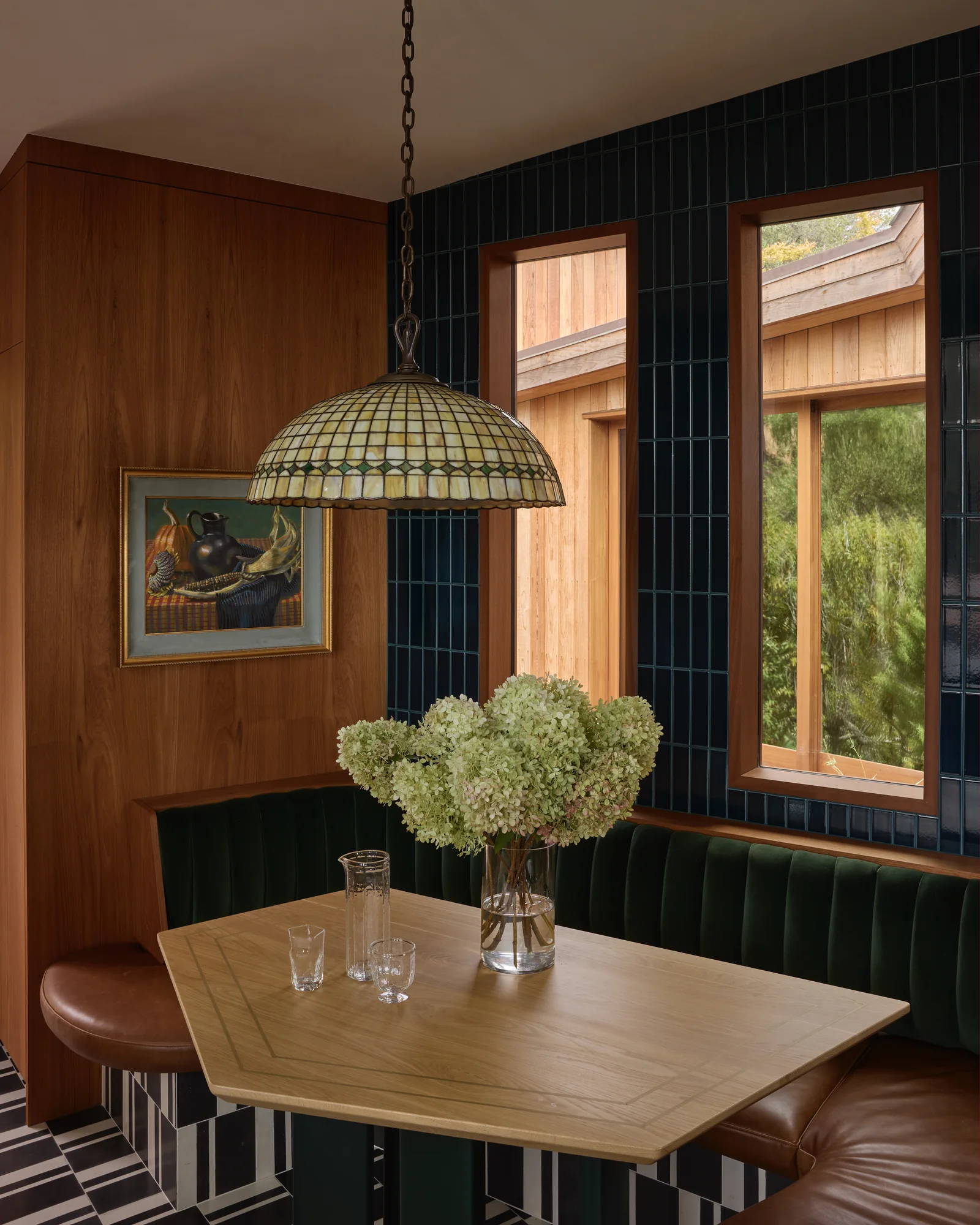 Breakfast nook with a green banquette under a stained-glass pendant
