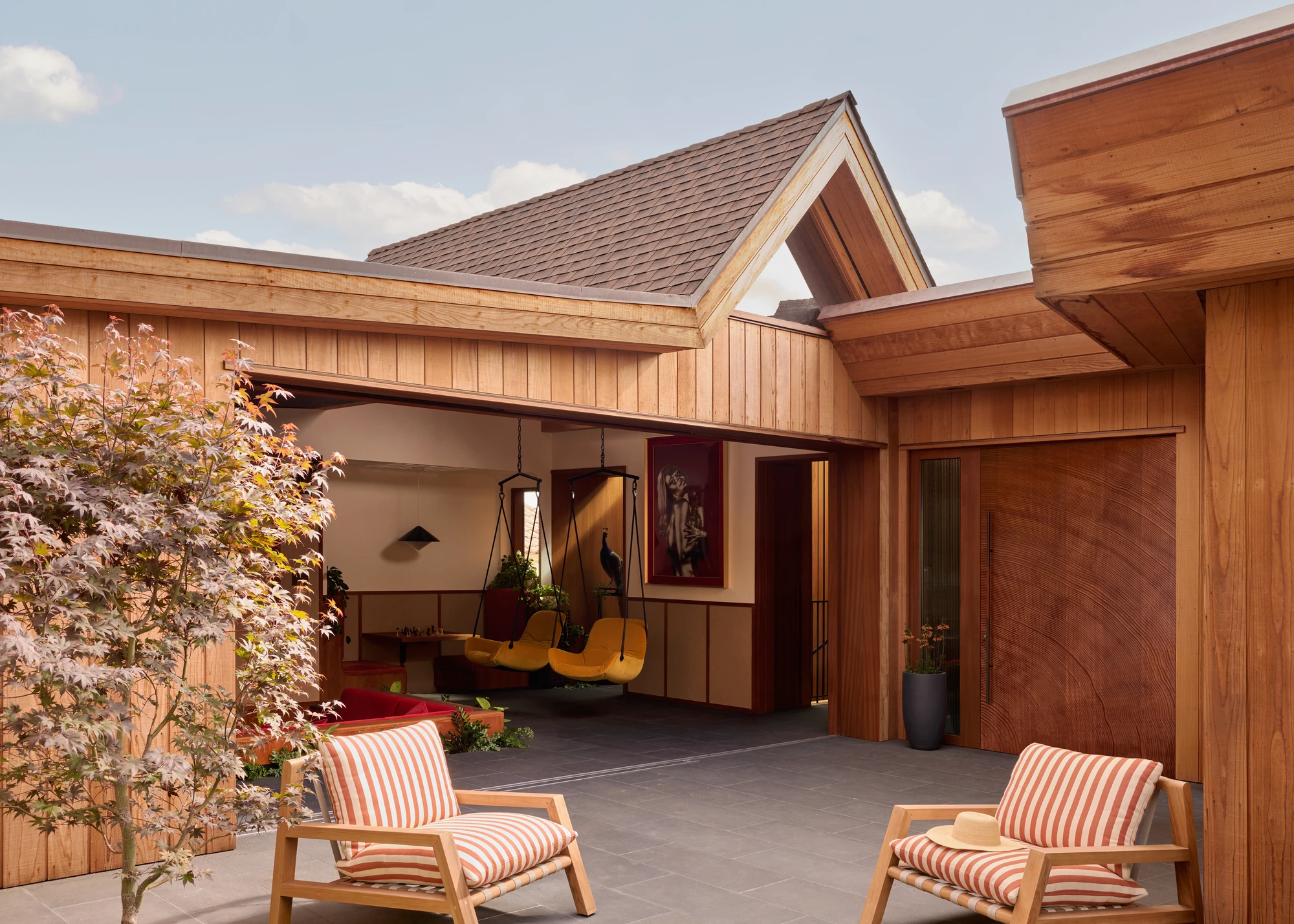 Gabled courtyard with striped lounge chairs and blossom