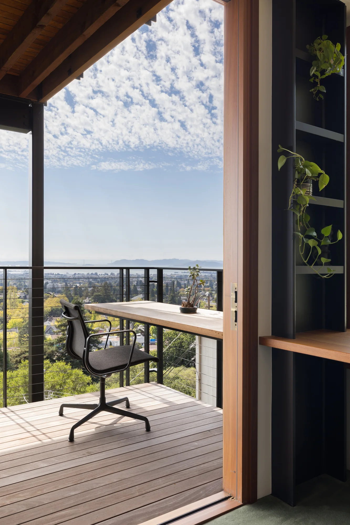 Office desk and chair opening onto the deck and the bay