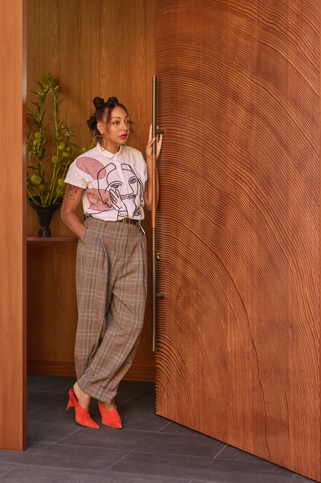 Woman standing in the carved wood pivot front door