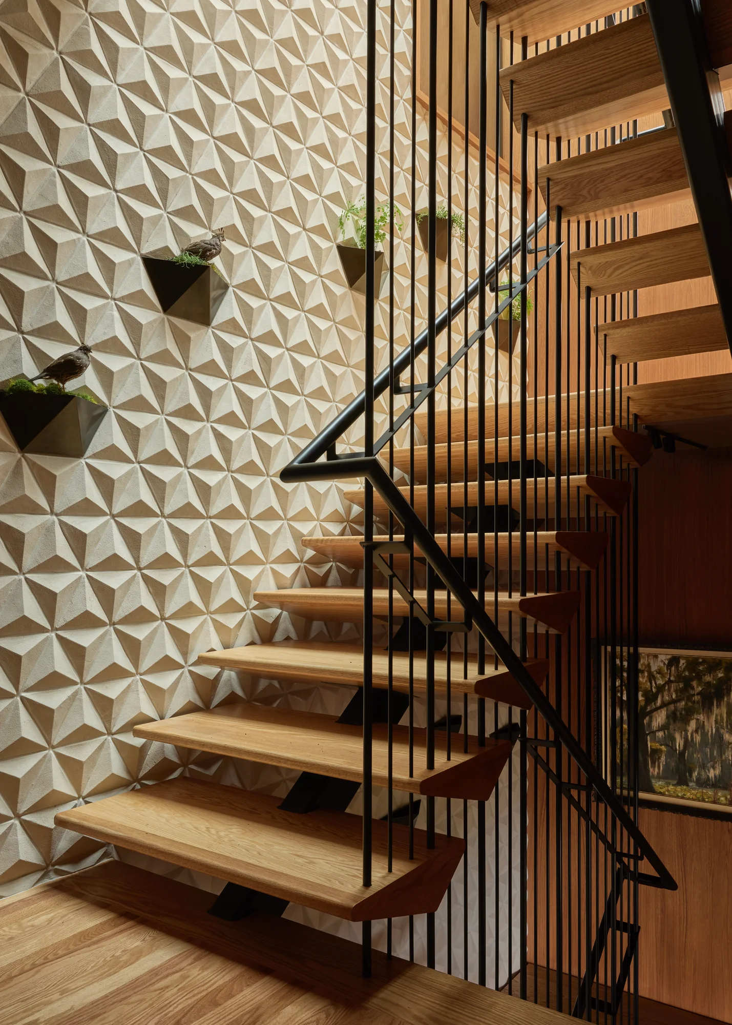 Faceted white tile feature wall running beside the open-tread stair